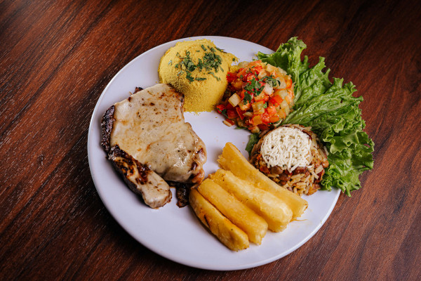 prato nordestino com carne, macaxeira frita, cuscuz, arroz com feijão, vinagrete e salada